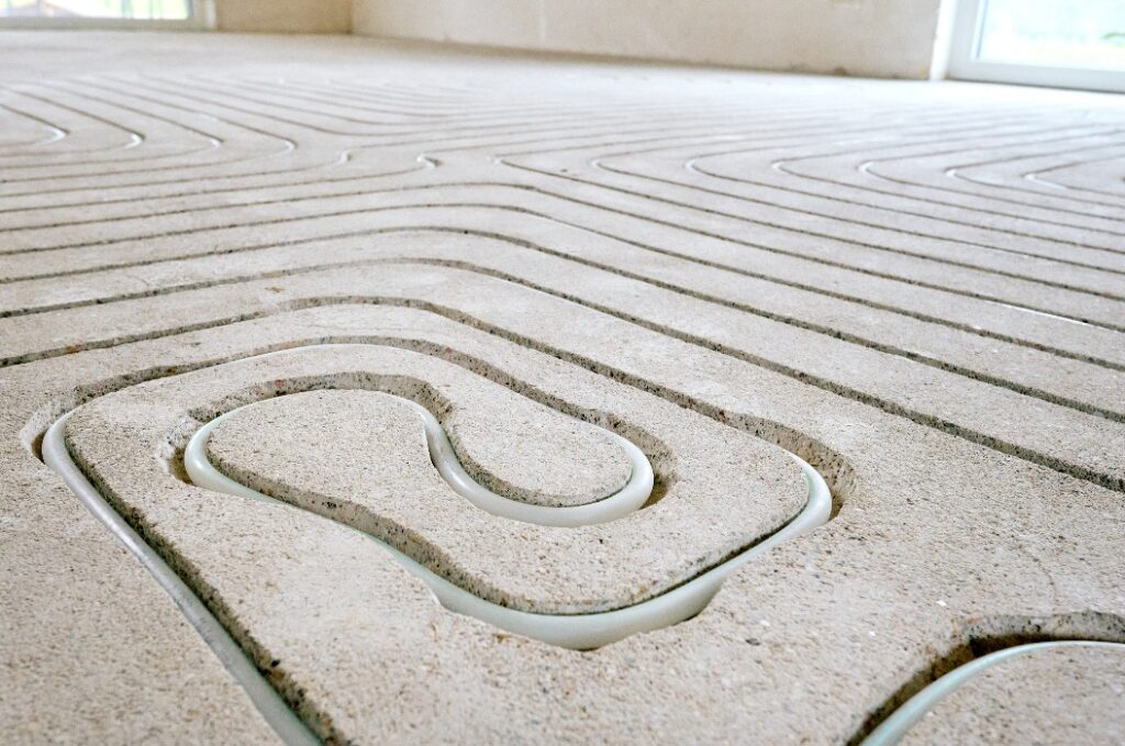 Fußbodenheizung wird in Estrich eingefräst bei einer Renovierung von Einfamilienhaus.