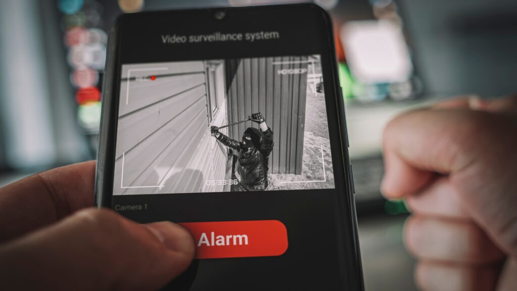 Aufnahmen der Videoüberwachung zeigen einen Einbrecher, der mit einer Brechstange durch ein Fenster in ein Haus eindringt.